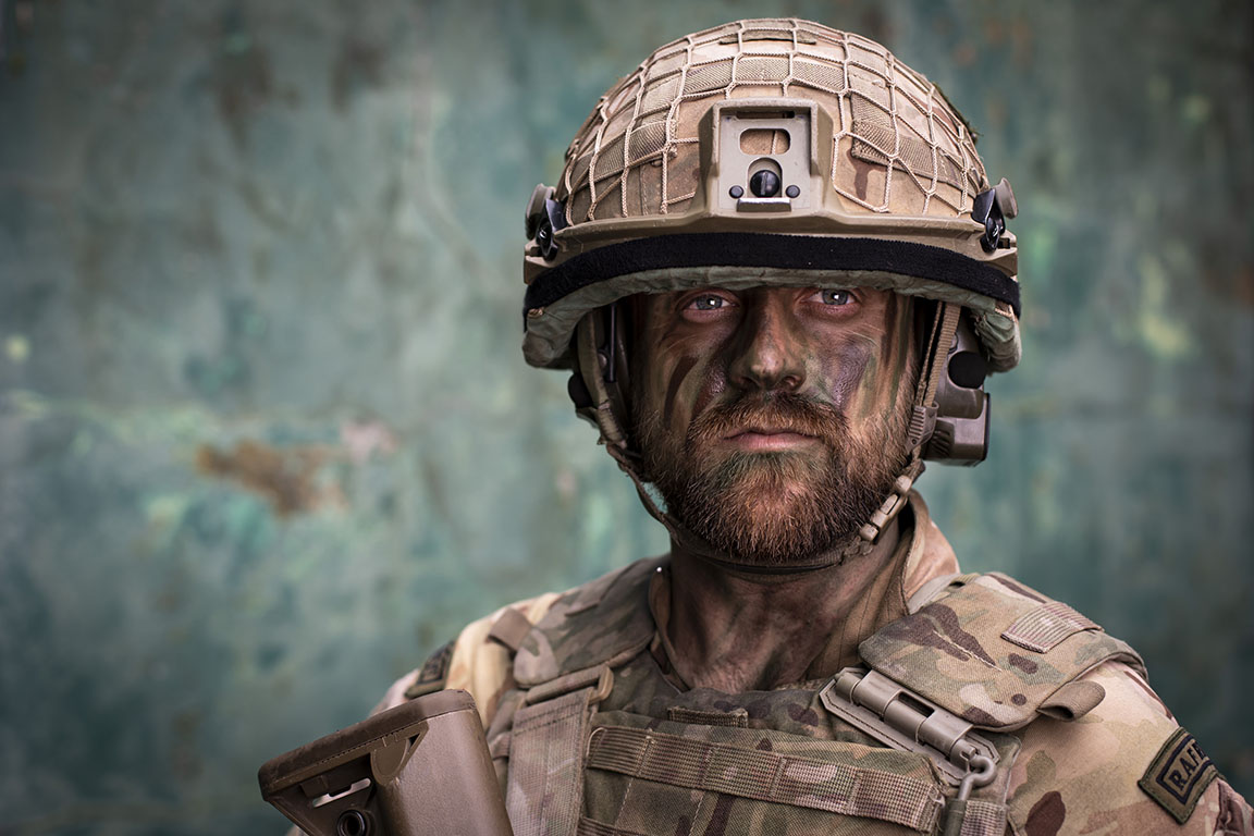 Image shows RAF Regiment with helmet and camouflage face paint. 
